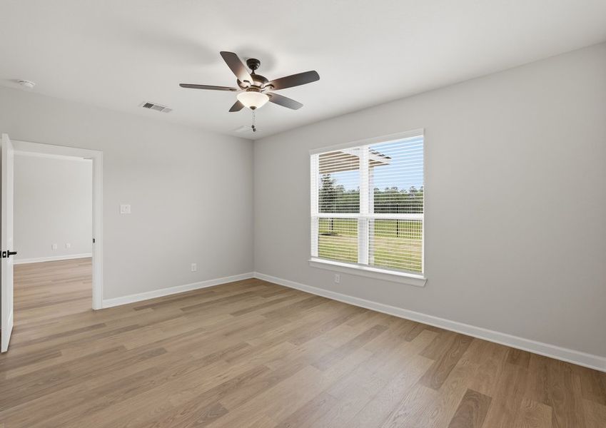 Second-floor game room featuring a ceiling fan, windows, and wood-look flooring.
