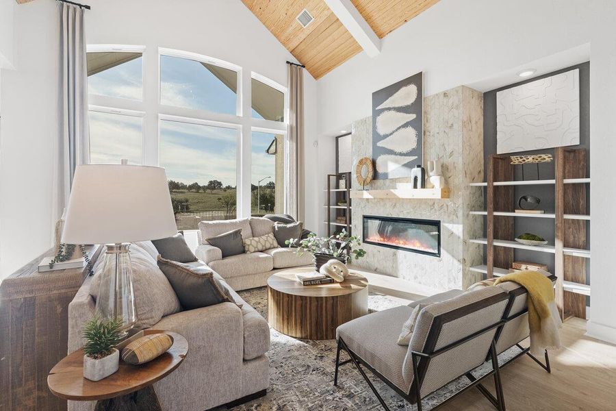 Living area featuring a high wooden beamed ceiling, a glass covered fireplace, wood finished floors, and built in features