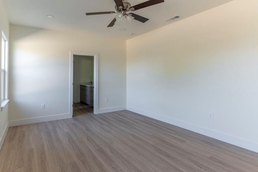 Empty room featuring light wood-type flooring and ceiling fan
