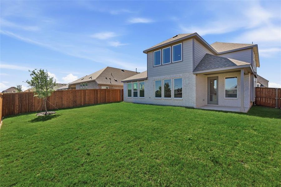 Back of house featuring brick siding, a fenced backyard, a patio, and a shingled roof
