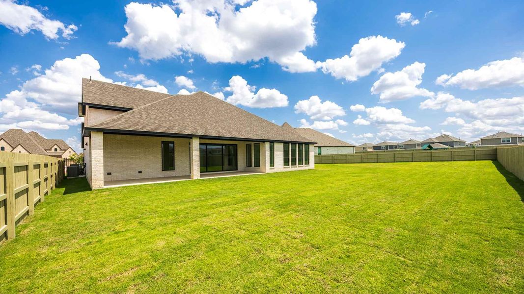 Rear view of house with roof with shingles, a fenced backyard, a patio area, and brick siding Rear view of house with roof with shingles, a fenced backyard, a patio area, and brick siding