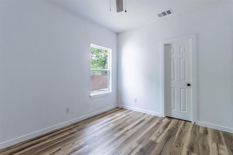 Spare room featuring light wood-type flooring, baseboards, and a ceiling fan Spare room featuring light wood-type flooring, baseboards, and a ceiling fan