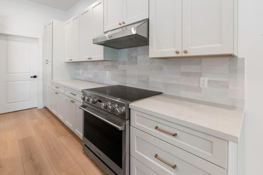 Bathed in natural light, this stunning kitchen showcases quartz countertops, statement designer pendants, a chic backsplash, and sleek hardware, with ample storage, a walk-in pantry, and a dedicated microwave niche—perfectly blending style and functionality. Bathed in natural light, this stunning kitchen showcases quartz countertops, statement designer pendants, a chic backsplash, and sleek hardware, with ample storage, a walk-in pantry, and a dedicated microwave niche—perfectly blending style and functionality.