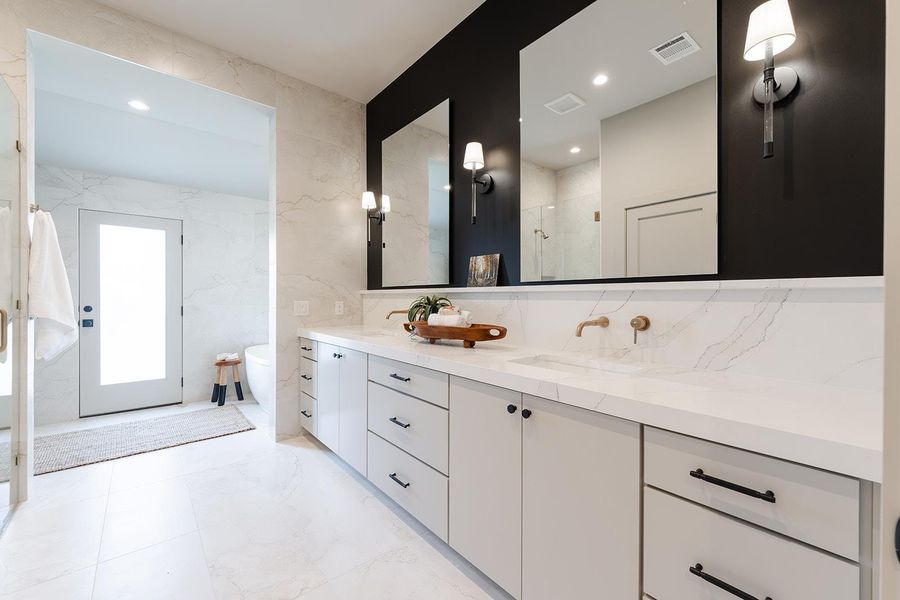 Bathroom with double vanity, a stall shower, recessed lighting, and tile walls