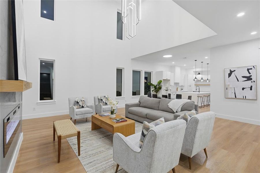 Soaring ceilings with a statement chandelier illuminate this open-concept living space Soaring ceilings with a statement chandelier illuminate this open-concept living space