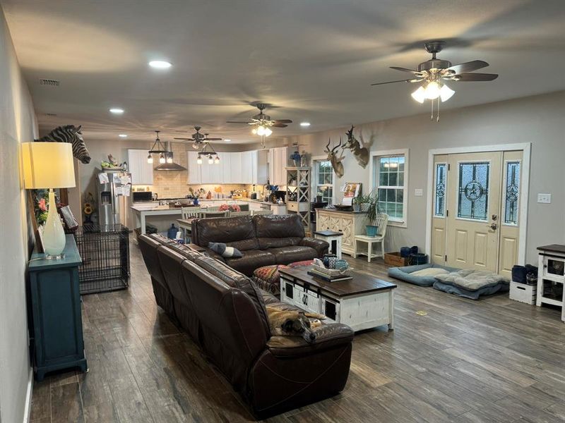 Living room with recessed lighting, dark wood-style flooring, and a ceiling fan Living room with recessed lighting, dark wood-style flooring, and a ceiling fan