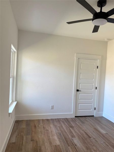 Spare room with dark wood-style flooring and a ceiling fan