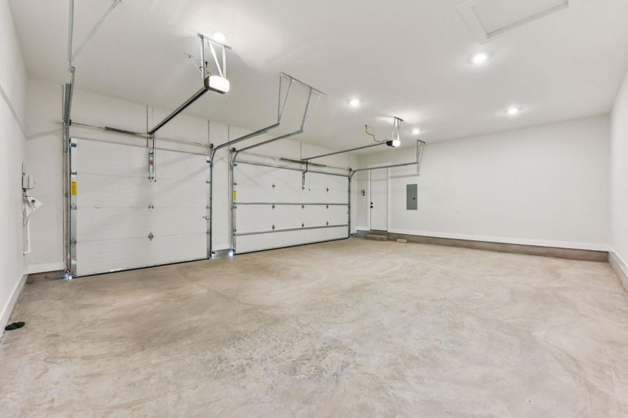 Garage featuring electric panel and a garage door opener