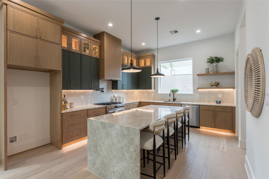 Full-kitchen specifications: a full-height oak pantry column anchoring the left flank, a stacked cabinet run along the range wall, glass-front illuminated display cabinets at the upper tiers, a veined-stone waterfall island centered in the floor plan, and floating oak shelves mirrored on the opposite wall. Every element squared to its neighbor.