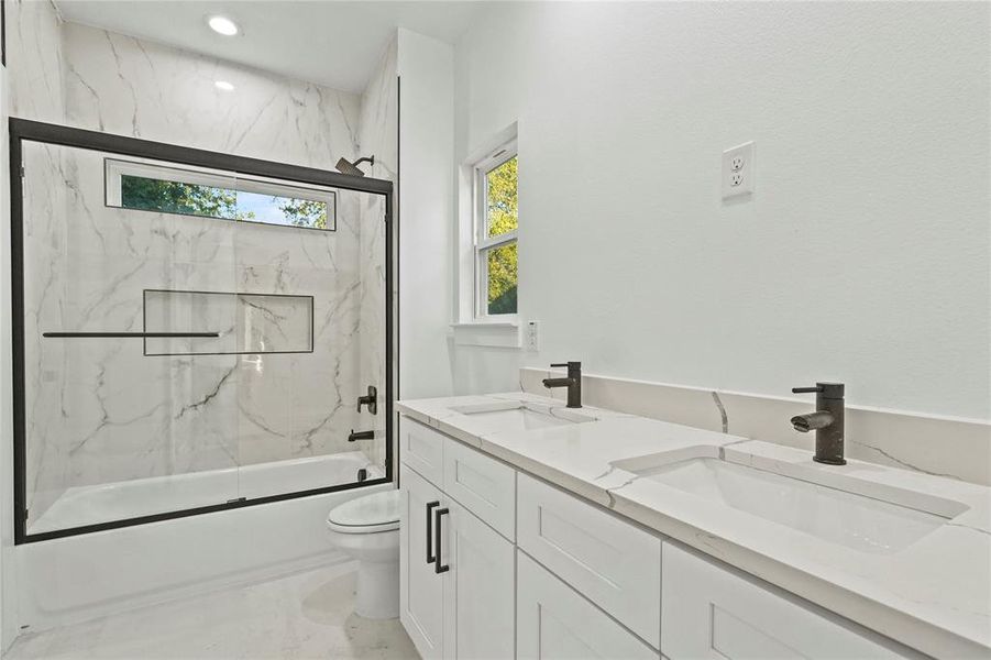 Bathroom featuring double vanity, combined bath / shower with glass door, and recessed lighting Bathroom featuring double vanity, combined bath / shower with glass door, and recessed lighting