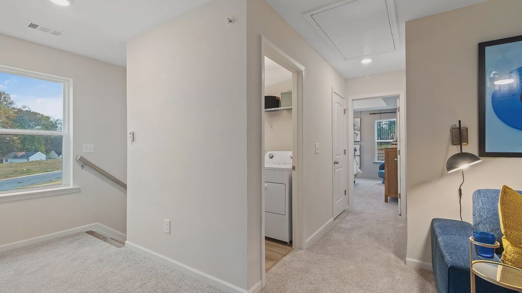 Upstairs landing with convenient laundry area and open hallway in new construction townhome at Auburn Ridge in Riverdale, GA.