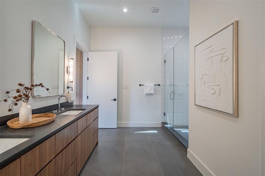 Bathroom with vanity, an enclosed shower, and tile patterned floors