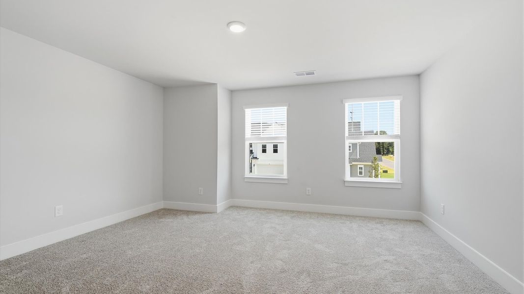 Memorable space with walk-in closet, soft carpeting, and striking natural light from large windows