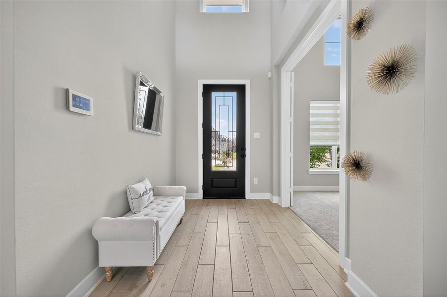 Step into a welcoming entry hall filled with natural light and modern finishes. The glass front door and open layout offer both style and functionality from the moment you arrive.