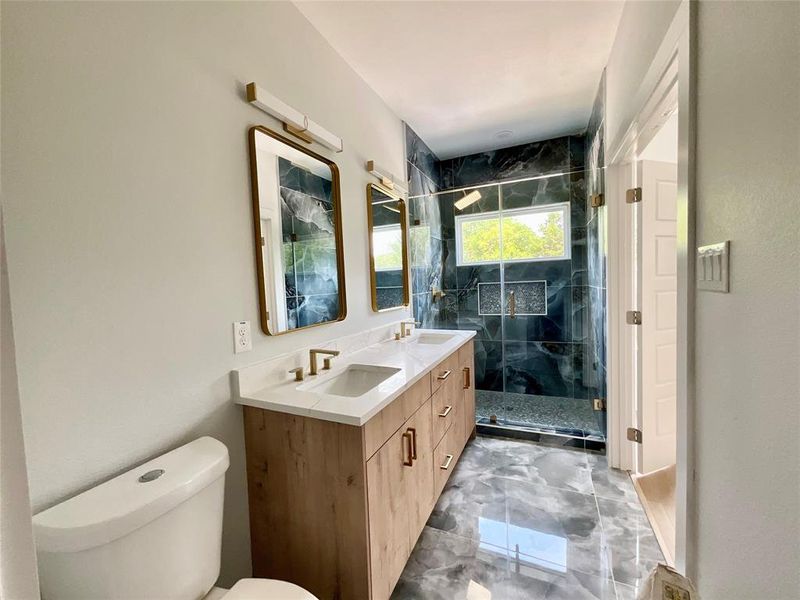 Modern bathroom featuring a dual vanity with wood-finish cabinetry and quartz countertops Modern bathroom featuring a dual vanity with wood-finish cabinetry and quartz countertops