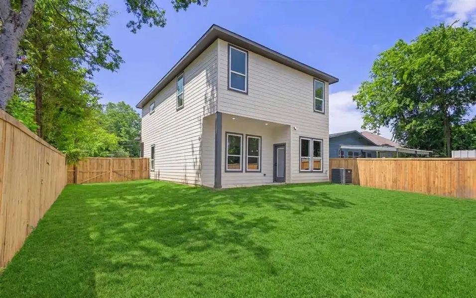 Spacious backyard featuring a lush lawn and perimeter wood fencing Spacious backyard featuring a lush lawn and perimeter wood fencing