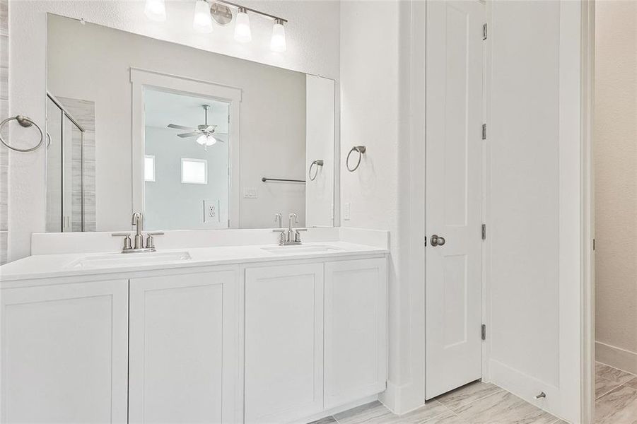 Bathroom featuring dual vanity, ceiling fan, and tile patterned floors