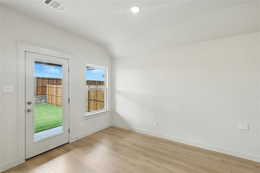 Doorway featuring wood finished floors, vaulted ceiling, and recessed lighting Doorway featuring wood finished floors, vaulted ceiling, and recessed lighting