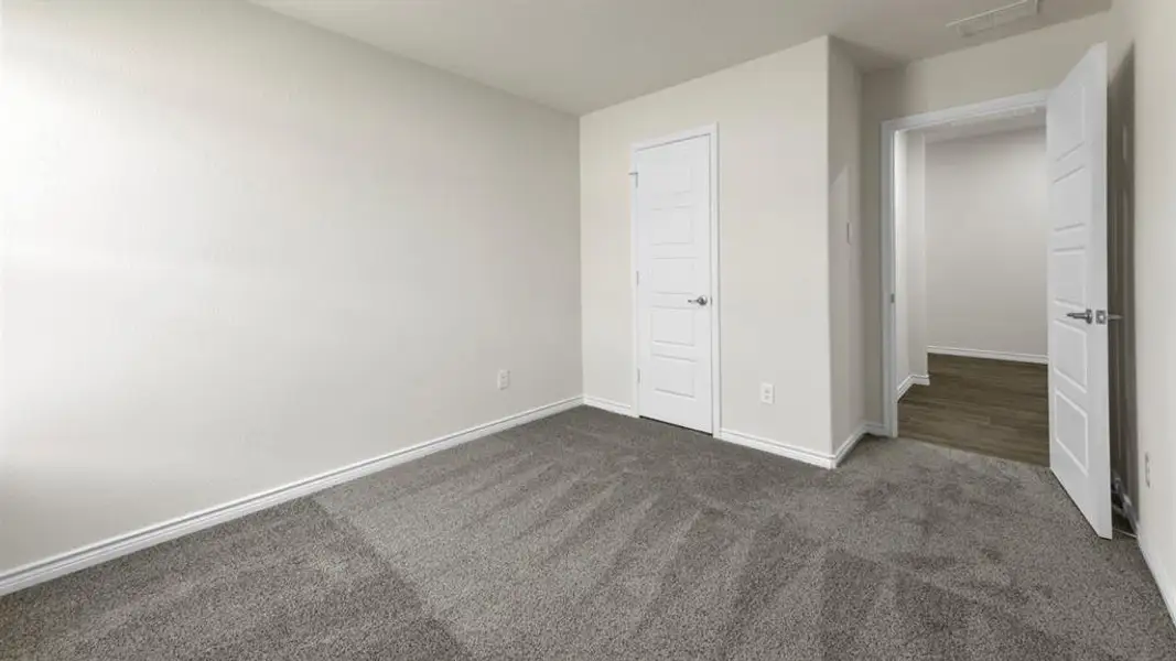 Interior room with light neutral wall paint and gray carpet flooring