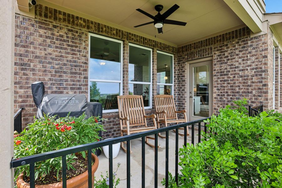 The property features a covered patio with brick exterior walls and a ceiling fan