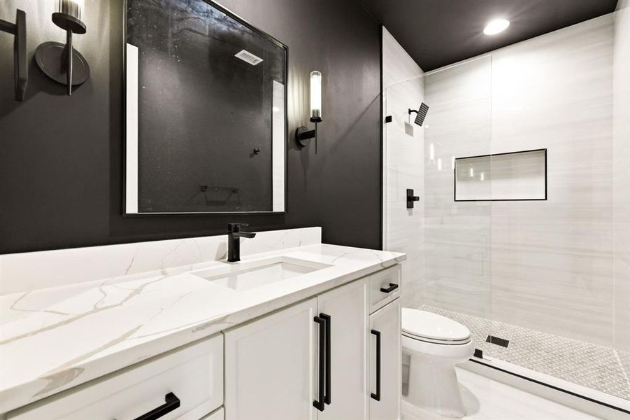 Full bathroom with vanity, tiled shower, and recessed lighting
