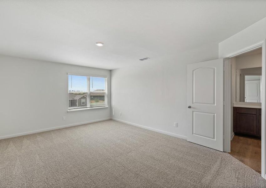 The spacious master bedroom has a large window that lets in natural light and backyard views.