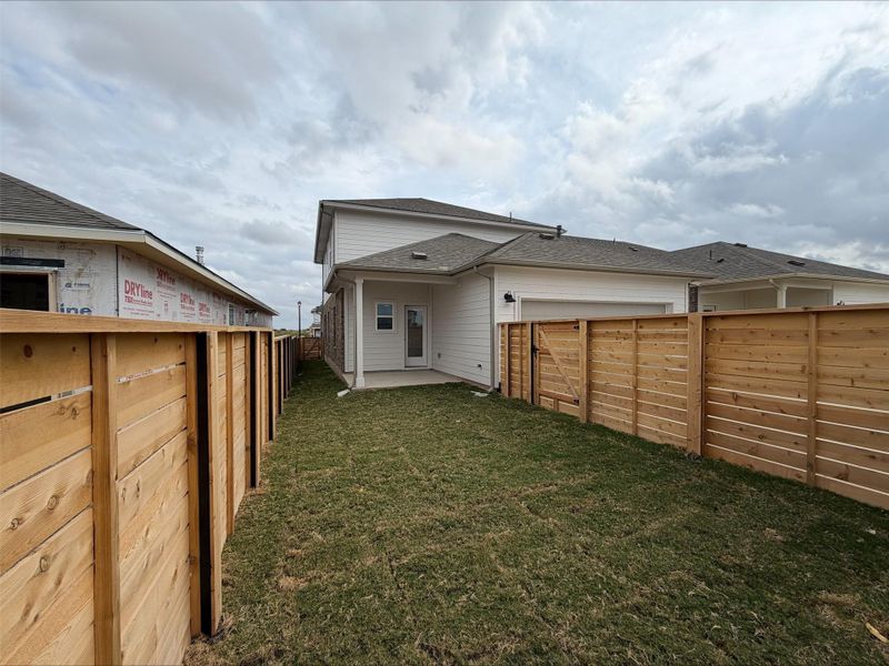 Back of house featuring a patio area, a fenced backyard, and an attached garage