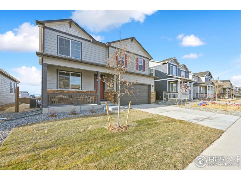 Front exterior of a new home in Silver Peaks, Lochbuie, CO, highlighting curb appeal (Image 2).