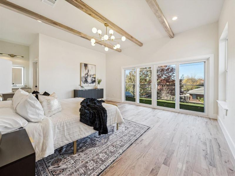 Bedroom featuring beam ceiling, access to exterior, light hardwood / wood-style flooring, and a notable chandelier