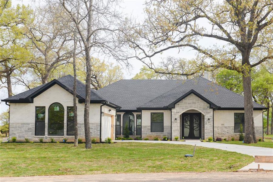 French country inspired facade featuring a front lawn