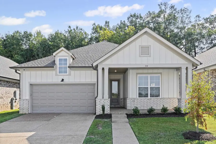 Modern farmhouse with board and batten siding, driveway, a shingled roof, and brick siding