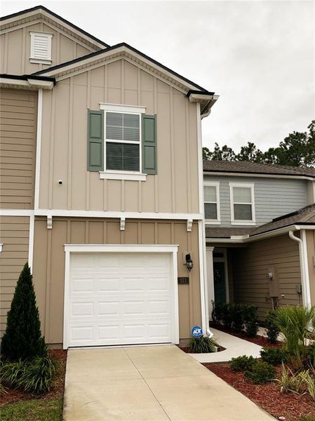 Front exterior of a new home in The Trails, Palm Coast, FL, highlighting curb appeal (Image 1).