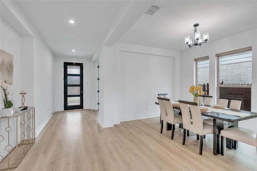 Clean lines and light-toned wood flooring define this open concept dining area.