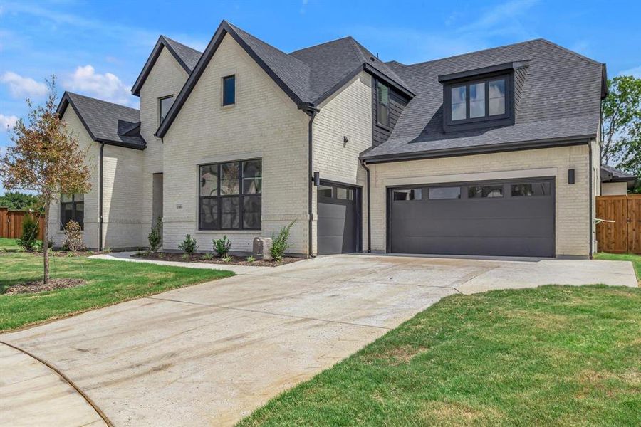 View of front of house featuring a garage and a front lawn