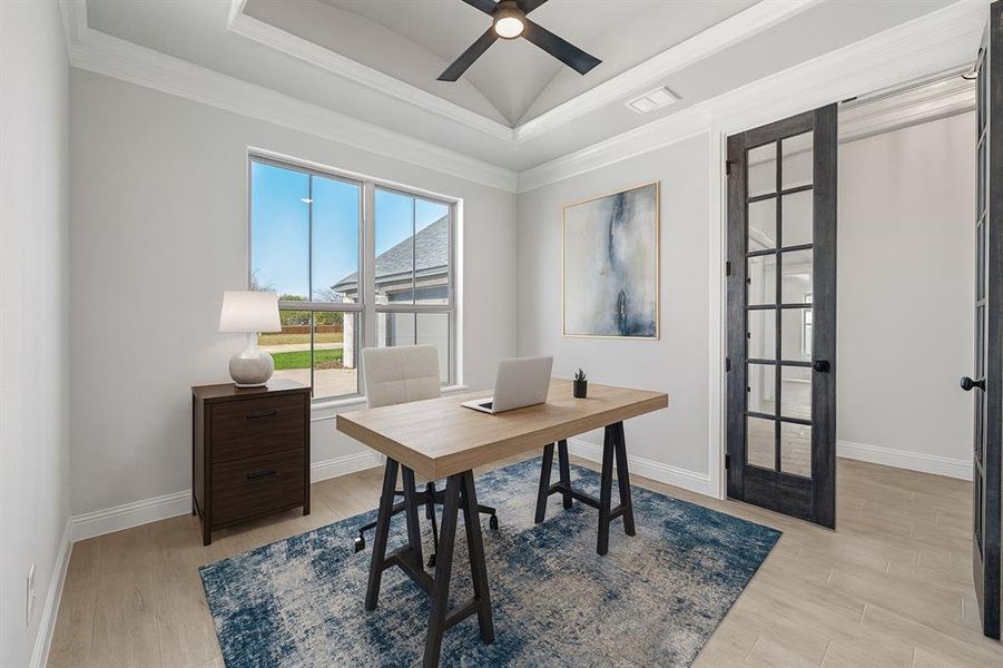 Office with a raised ceiling, light wood finished floors, crown molding, and ceiling fan
