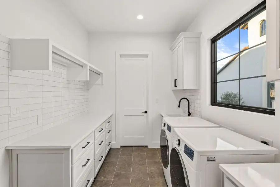 Laundry room with cabinet space, washer and dryer, and recessed lighting