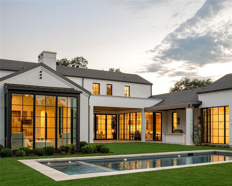 Back of house at dusk with a patio, a tiled roof, and a chimney Back of house at dusk with a patio, a tiled roof, and a chimney