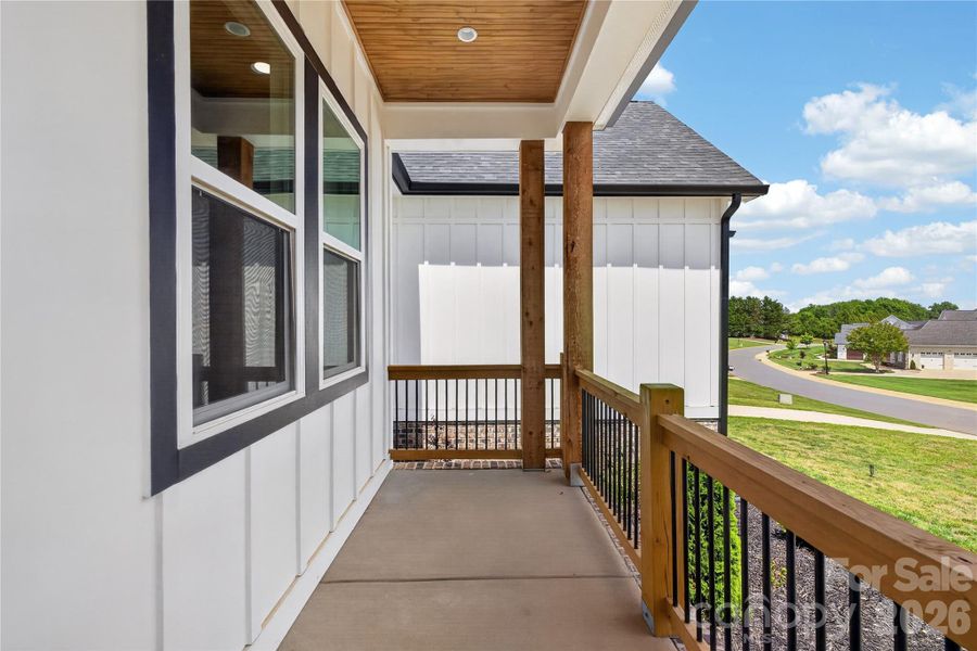 Covered front porch with warm wood ceiling details enjoying your morning coffee
