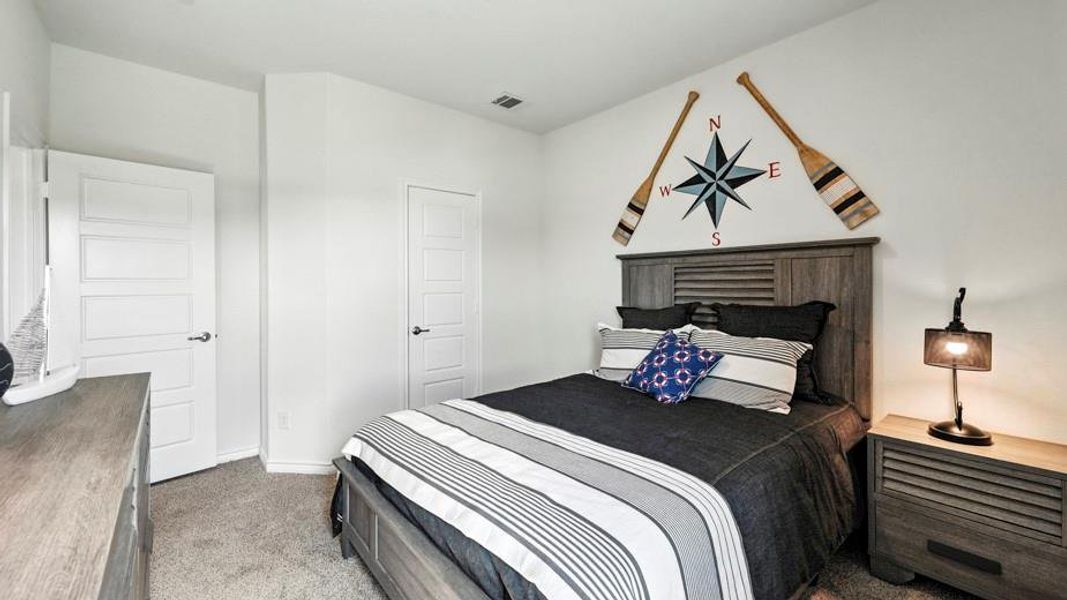 The bedroom features light gray carpeting and white walls, offering a neutral palette