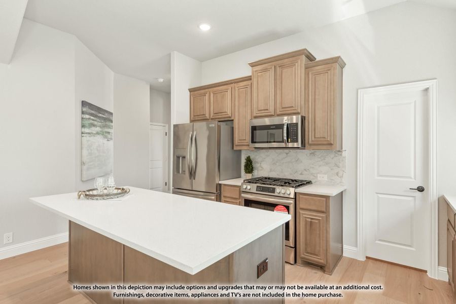 Kitchen with center island, tan wood cabinets, marble backsplash, and stainless steel appliances Kitchen with center island, tan wood cabinets, marble backsplash, and stainless steel appliances