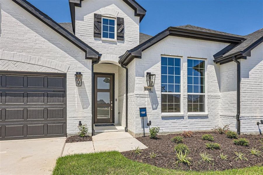 View of exterior entry with a garage