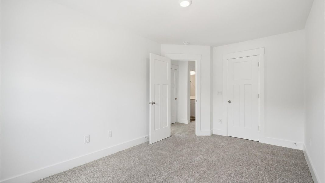 Elegant bedroom retreat featuring soft carpeting and a thoughtfully designed walk-in closet by DRB Homes