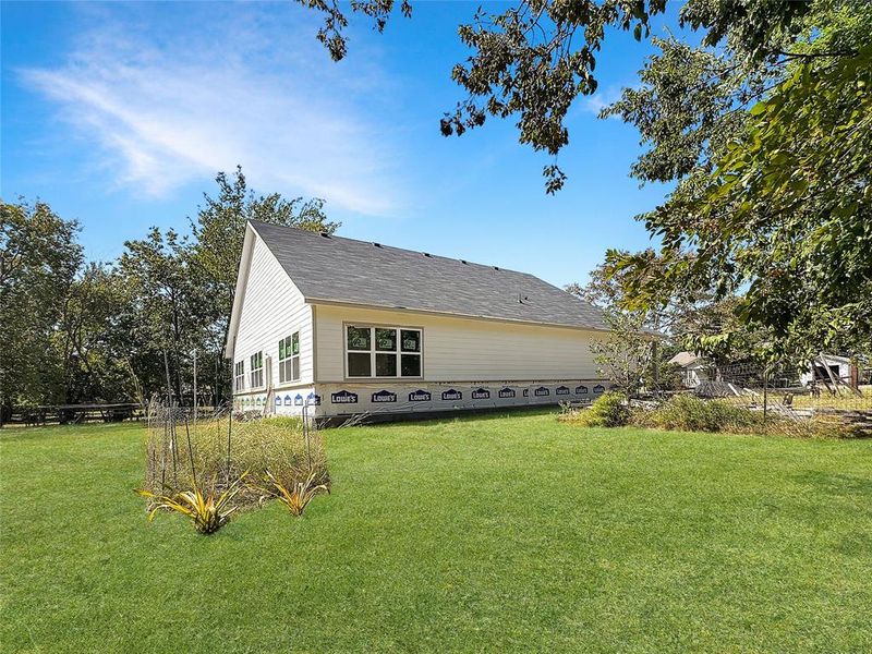 View of property exterior featuring a yard and a shingled roof View of property exterior featuring a yard and a shingled roof