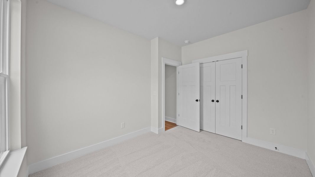 Accomplished design shines in this carpeted bedroom with a functional walk-in closet