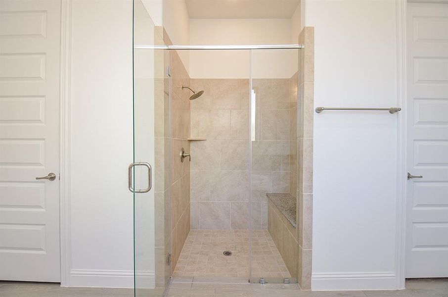 Large separate shower with seat, and walk in closet.