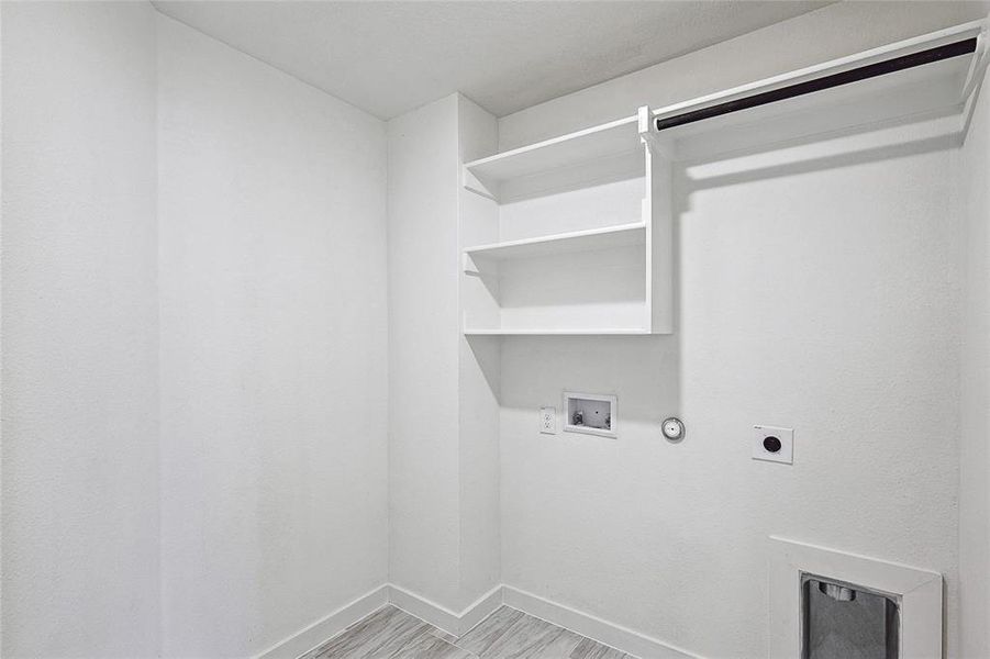 Laundry area with washer hookup, hookup for an electric dryer, light hardwood / wood-style floors, and gas dryer hookup