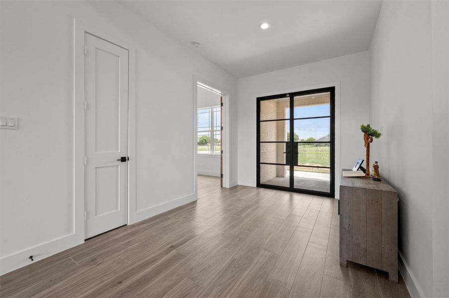 Formal entry with double glass front doors and office space on the right