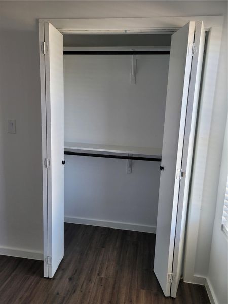 Ample storage solutions await in this well-appointed closet, featuring durable wood flooring.