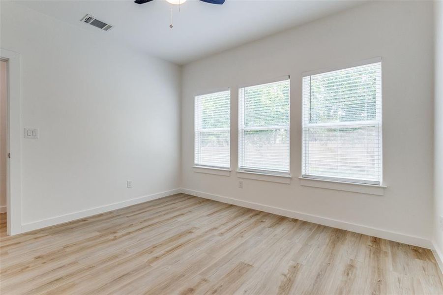 Unfurnished room featuring light hardwood / wood-style flooring, a wealth of natural light, and ceiling fan