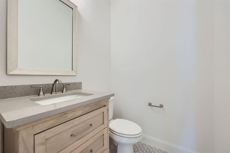 Bathroom featuring vanity, toilet, and tile patterned floors